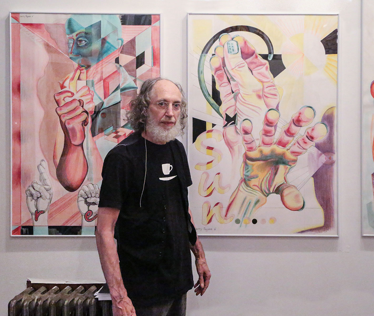 Jerry Pagane in front of his paintings